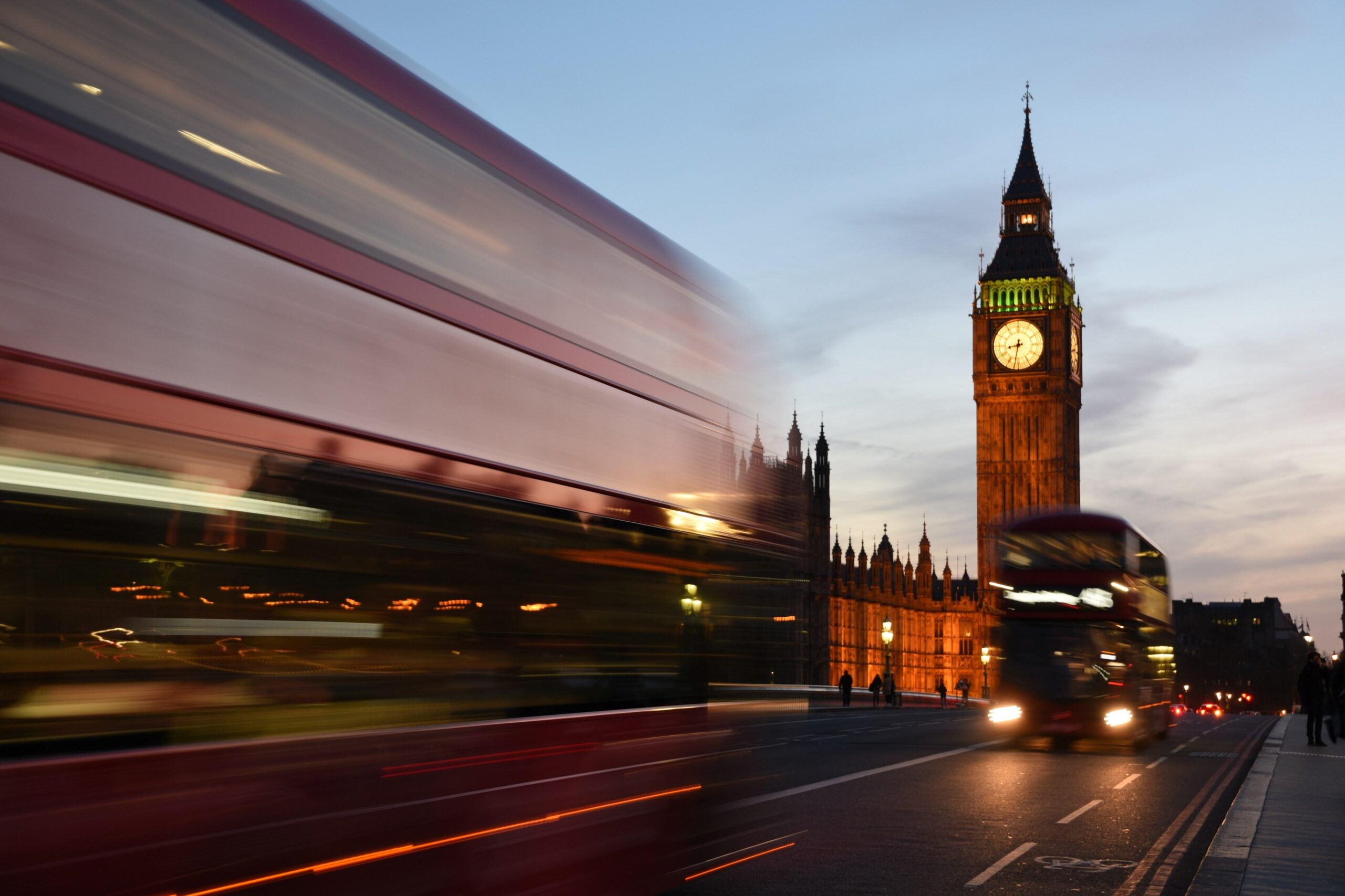 a long exposure shot of double decker buses near the houses of