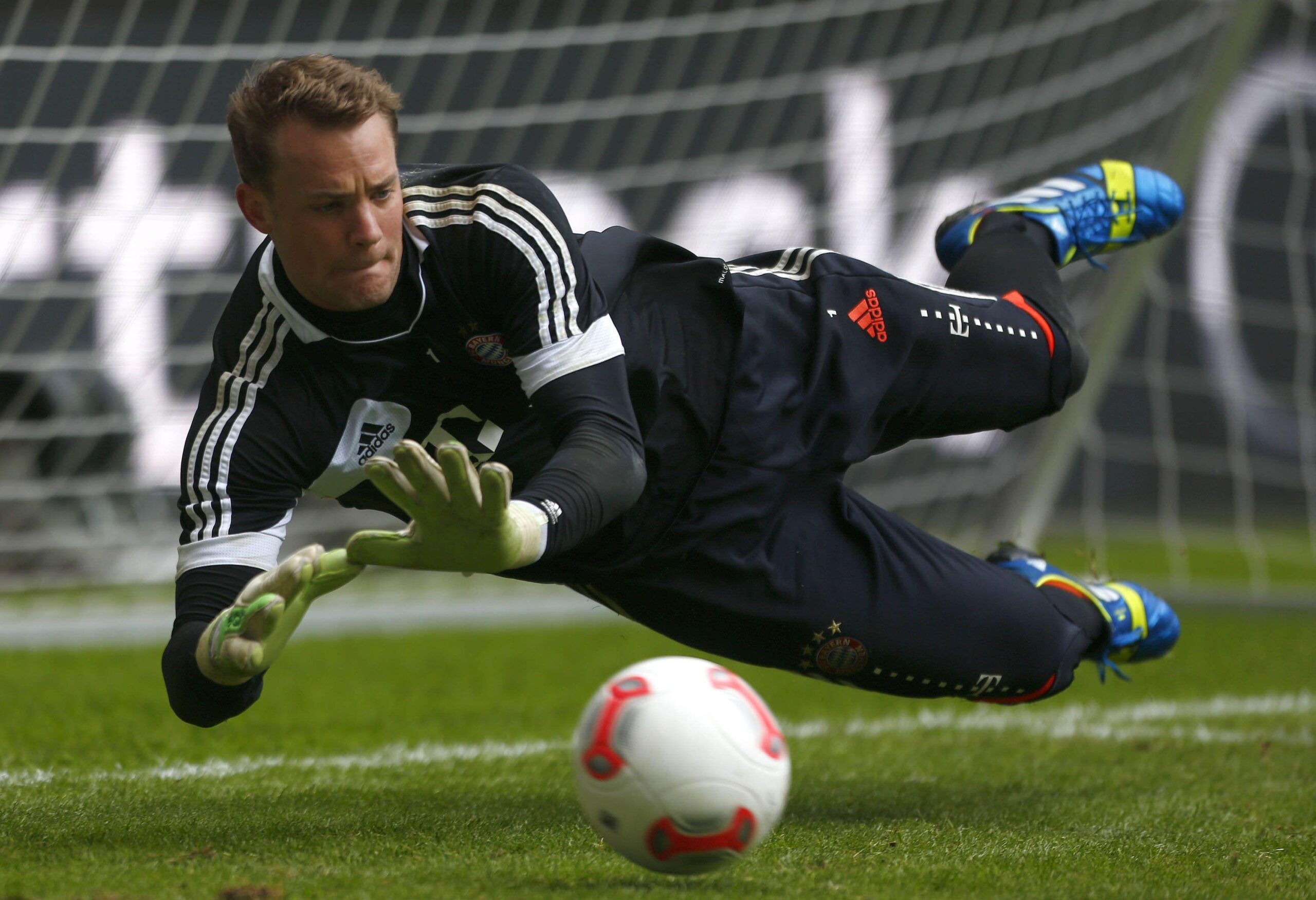 The goalkeeper of Bayern Manuel Neuer is catching a ball