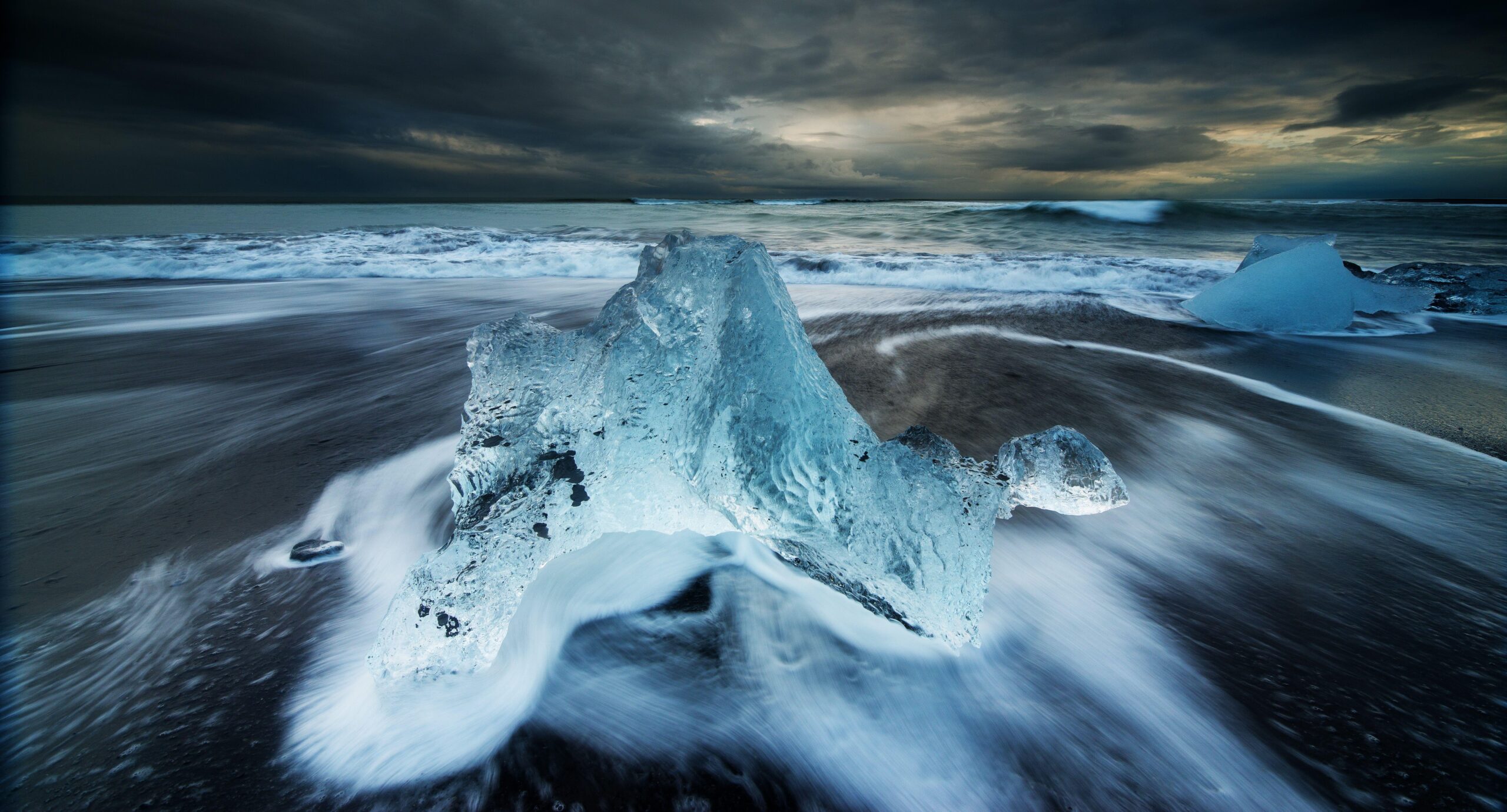 Grey stone formation near water with dark sky HD wallpapers