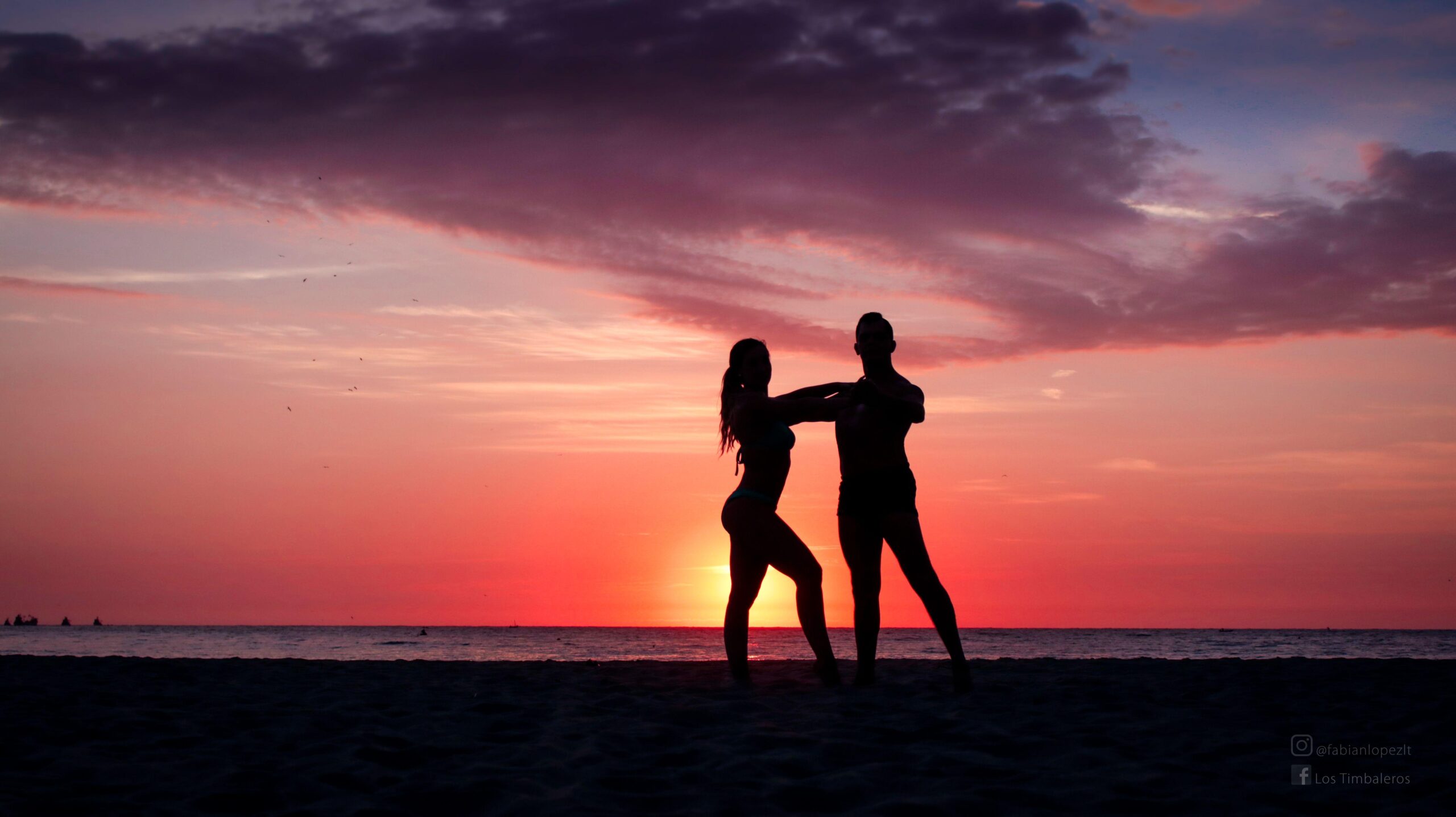 Pareja bailando en la playa al atardecer silueta sombra