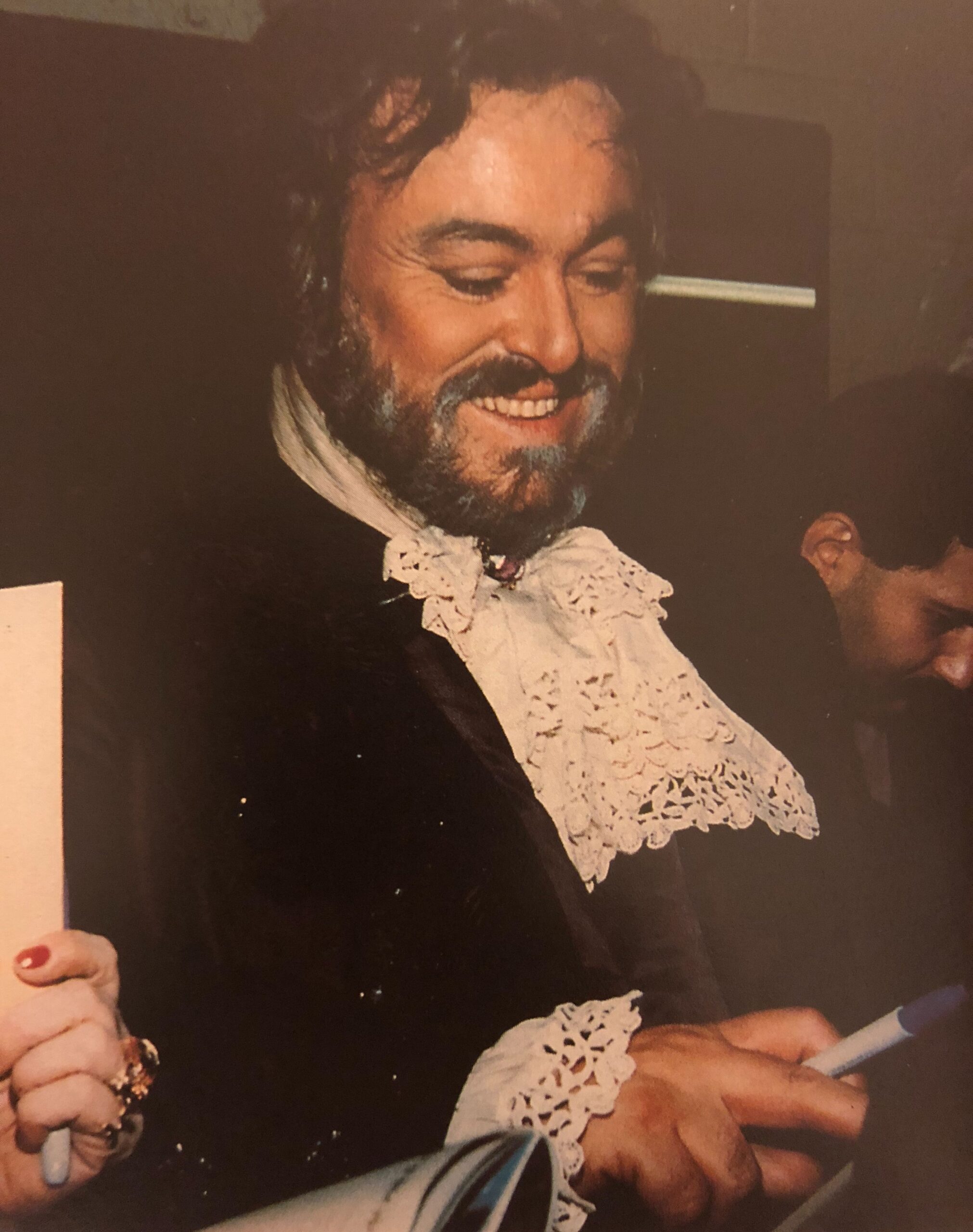 Luciano Pavarotti signs autographs backstage after a performance of