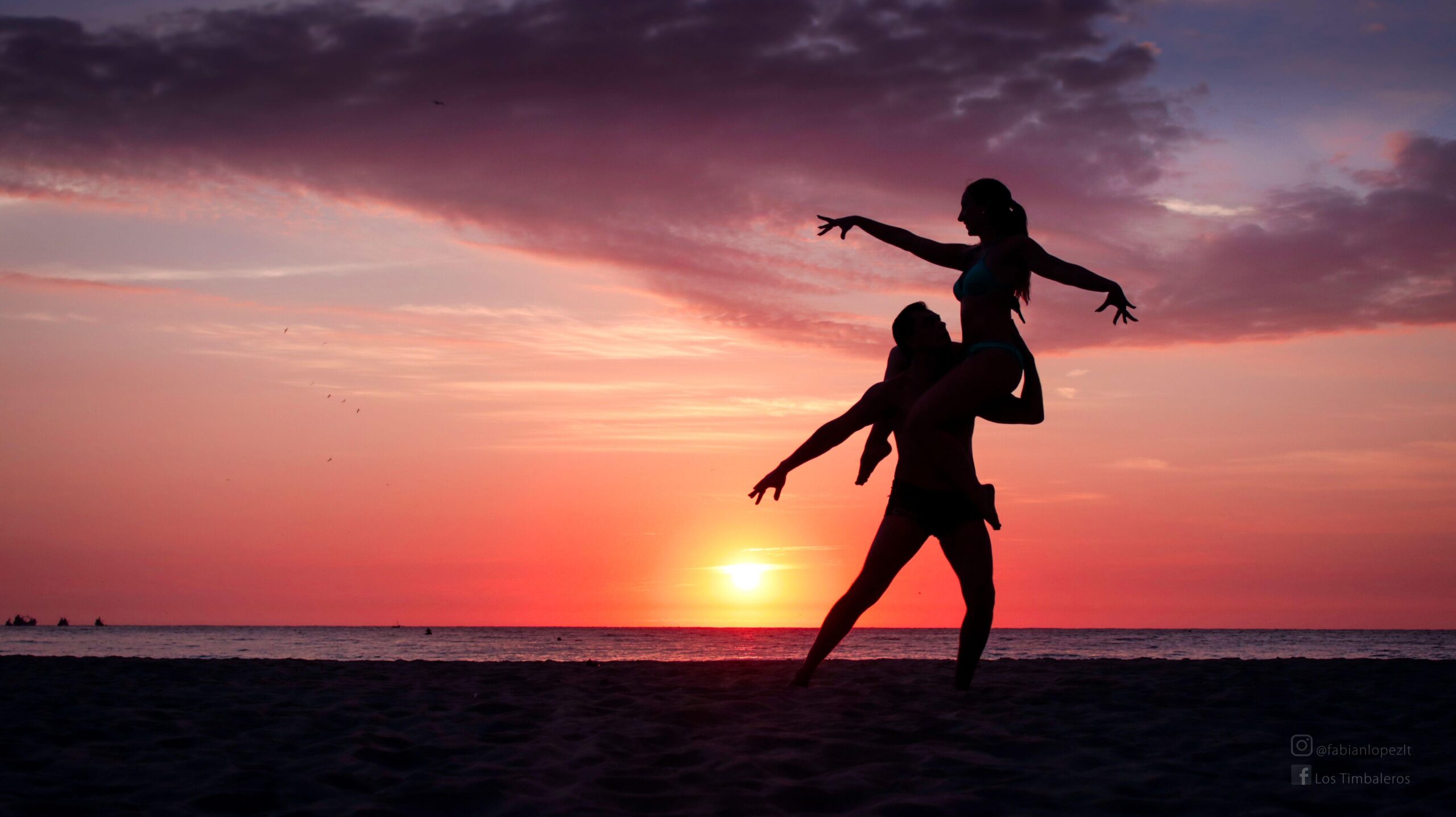 Pareja bailando en la playa al atardecer silueta sombra