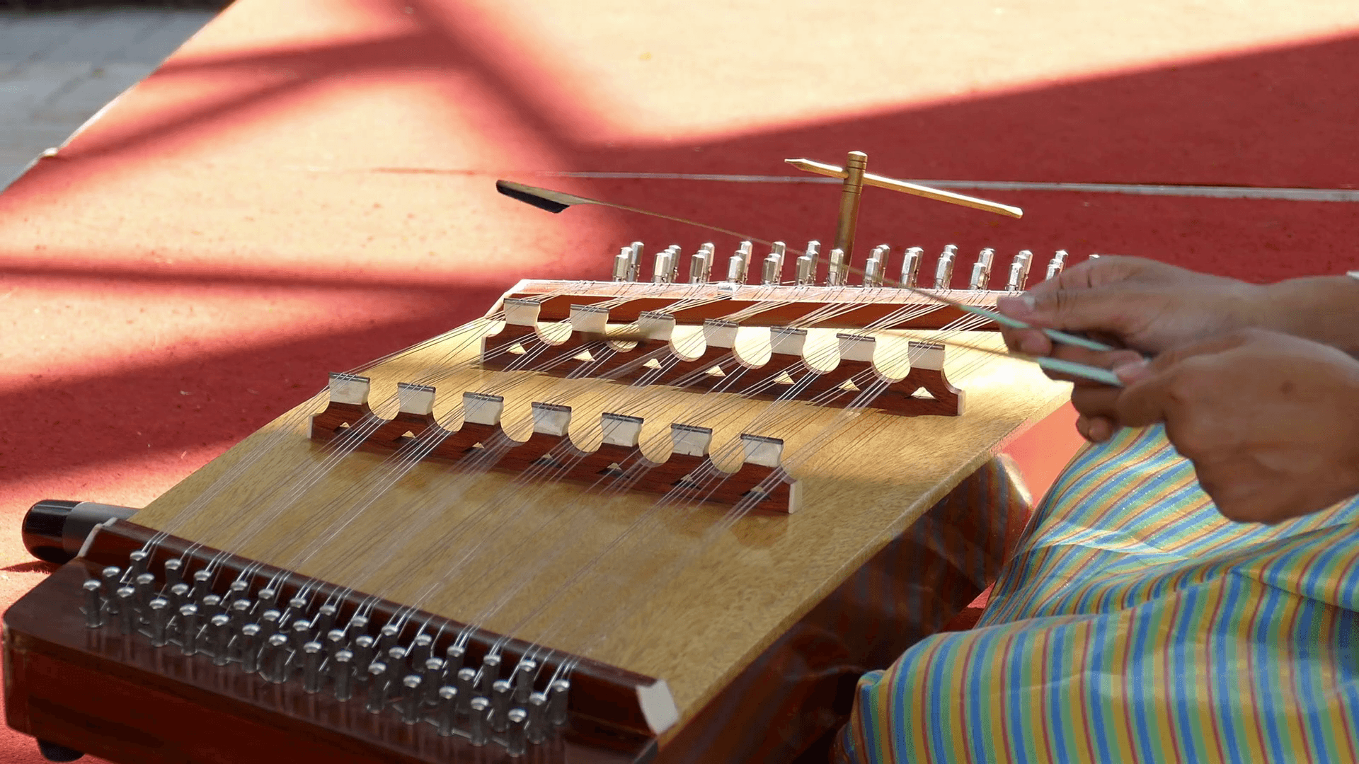 A young asian woman in thailand traditional cloth plays a song on a